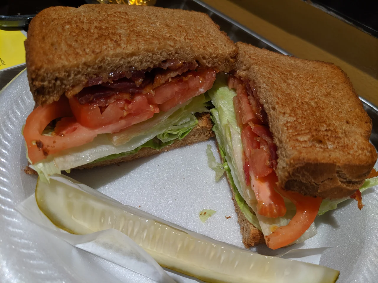 Both halves of Avenue Cafe’s BLT on toasted bread, with a pickle spear.